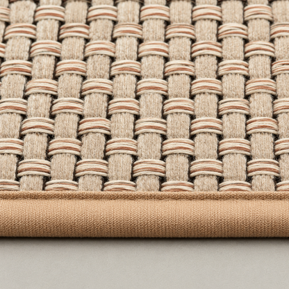 Close-up of the flat over-and-under weave and the bound camel edge tape of the beige rug