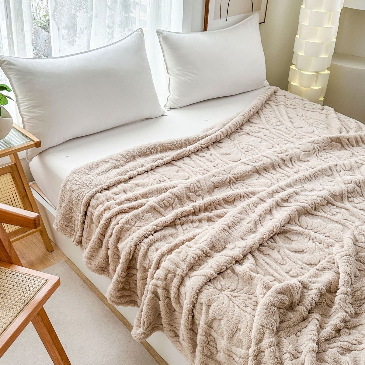Beige damask fleece blanket spread across a bed