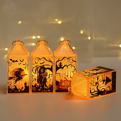 Three lit mini Halloween lanterns standing in a row with a fourth lying on its side in front