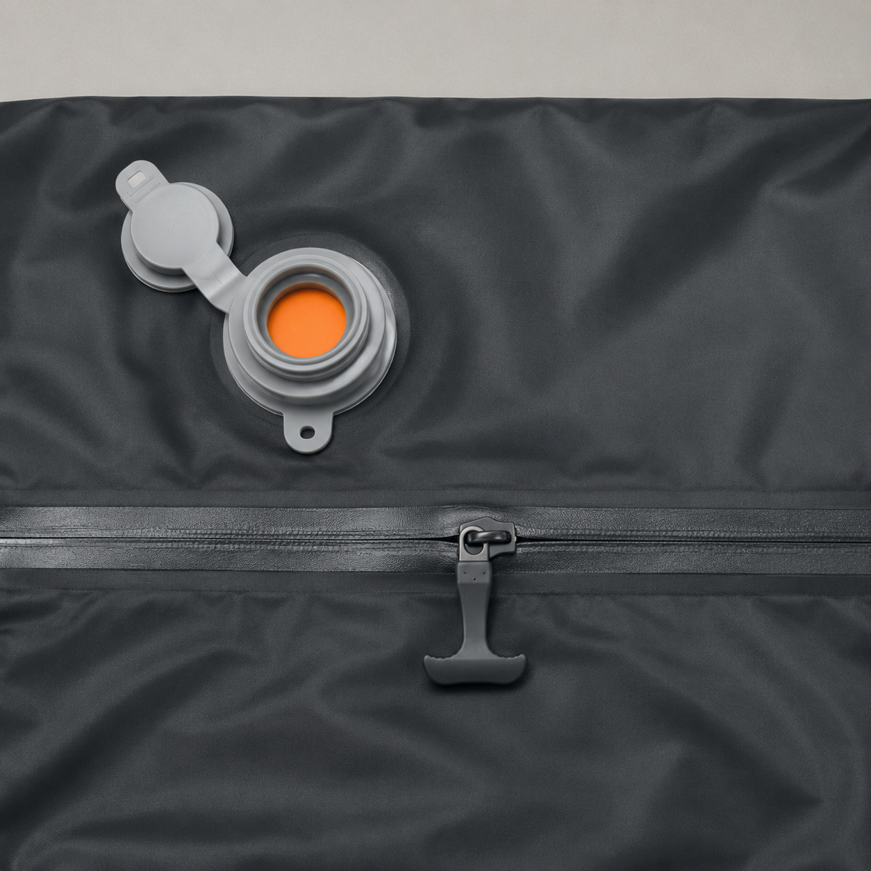 Close up of the compression chamber's grey air valve with its orange one way disc, and the airtight zip with its moulded paddle pull