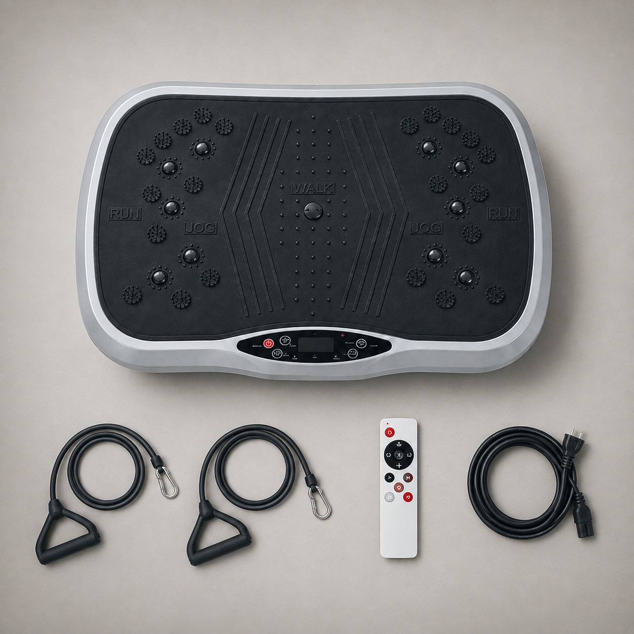 Vibration plate with two resistance bands, wireless remote and power cord laid out on grey