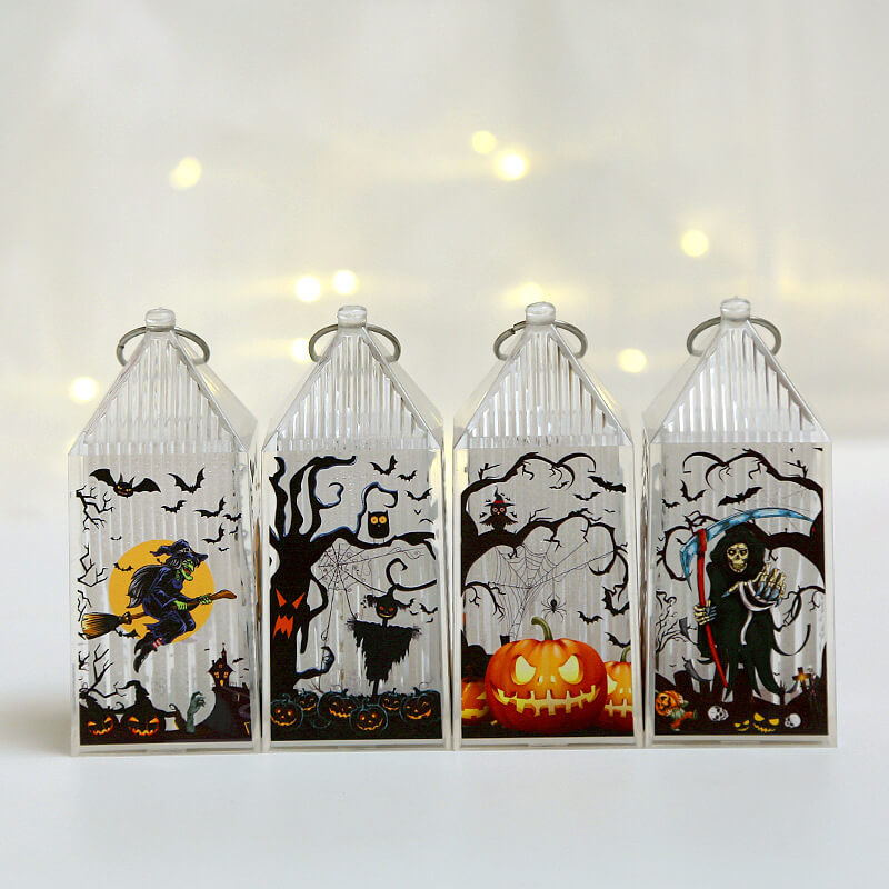 Four mini Halloween lanterns switched off, showing the printed witch, scarecrow, pumpkin and reaper scenes in color