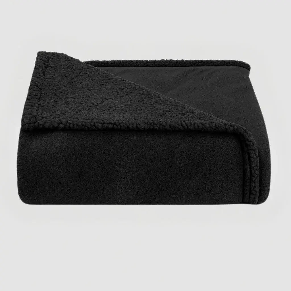 Black waterproof blanket folded to show its plush face and sherpa reverse