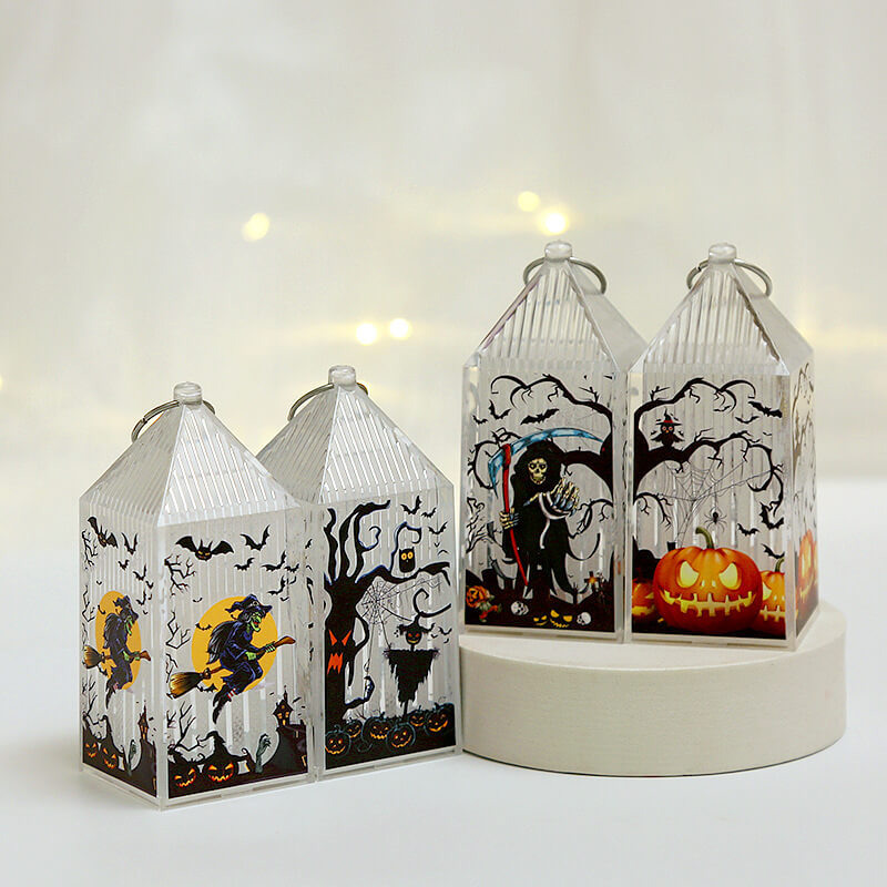 Four mini Halloween lanterns switched off in a bright room, two standing on a round plinth