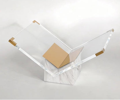 White and gold marble stand seen from above, with a gold-toned cap on each outer corner of the acrylic
