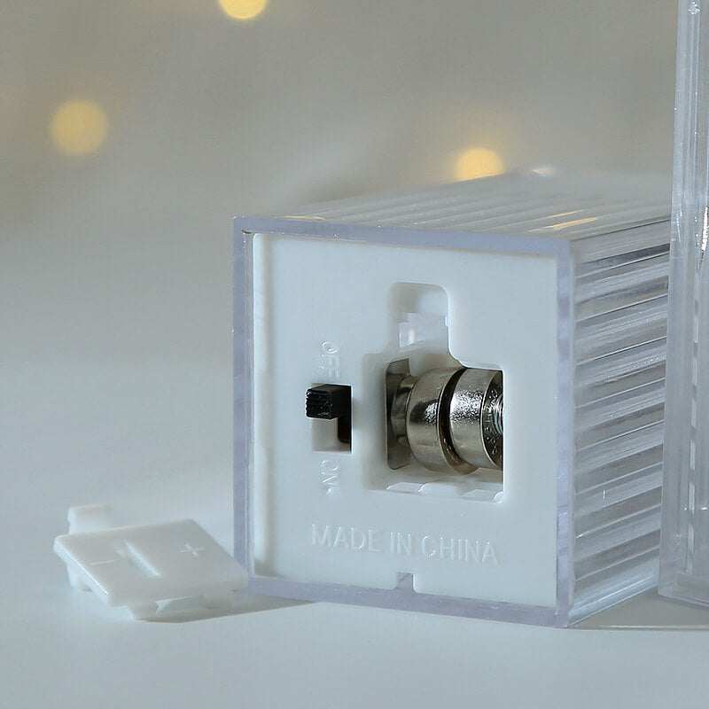 Underside of a mini Halloween lantern showing the on and off slide switch, two button cells and the clip-off cover