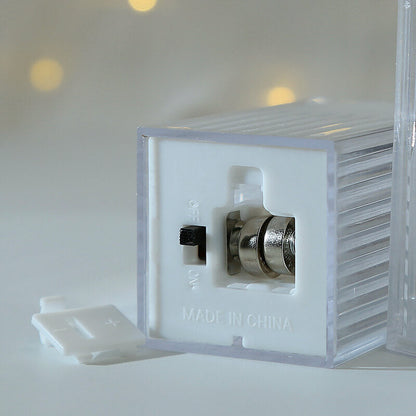 Underside of a mini Halloween lantern showing the on and off slide switch, two button cells and the clip-off cover