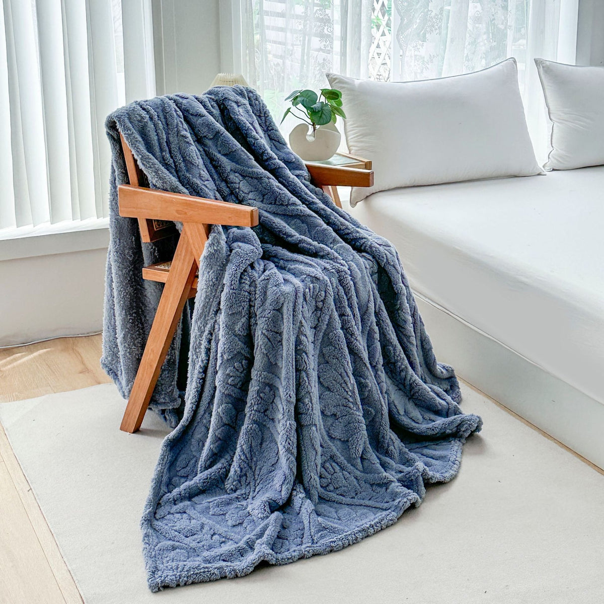 Blue fleece blanket draped over a wooden armchair