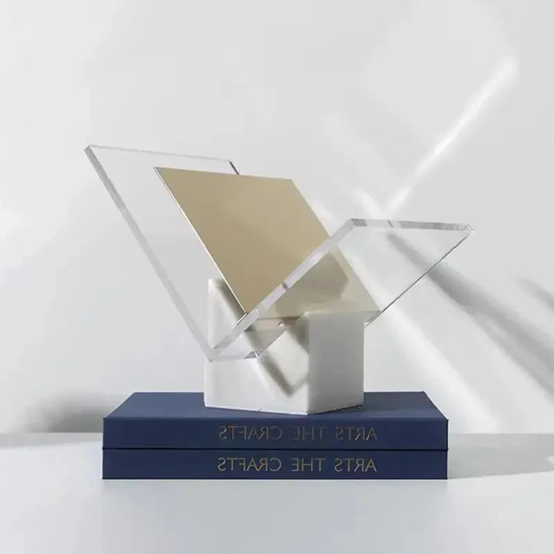 White marble magazine holder with a gold-toned divider, on two navy books