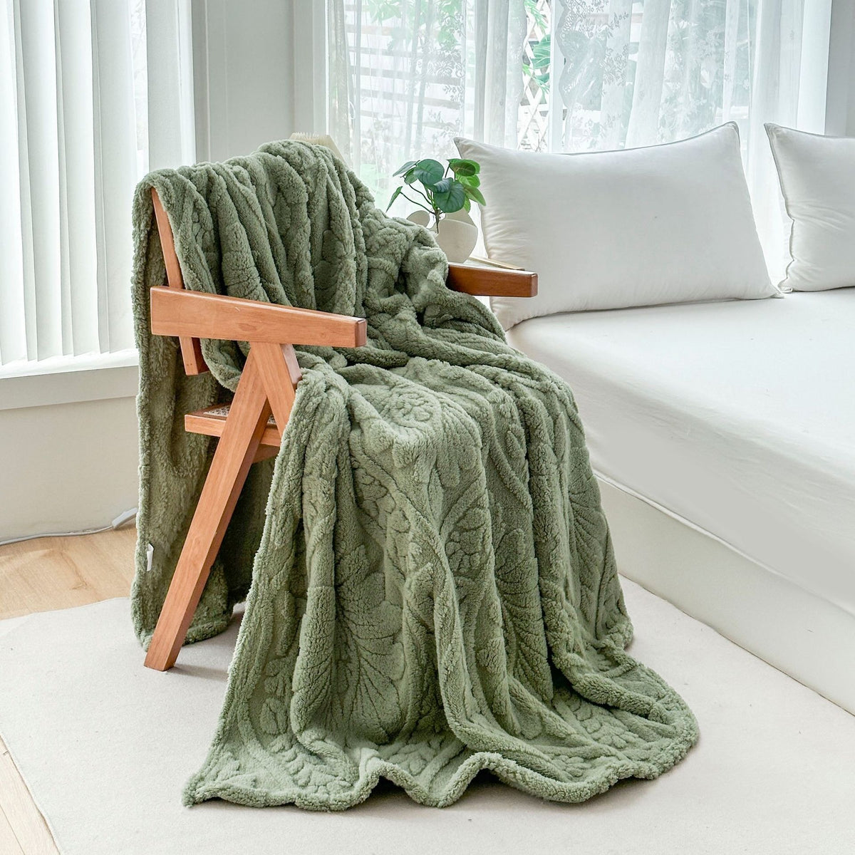 Green fleece blanket draped over a wooden armchair