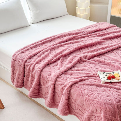 Pink damask fleece blanket spread across a bed with a small tray