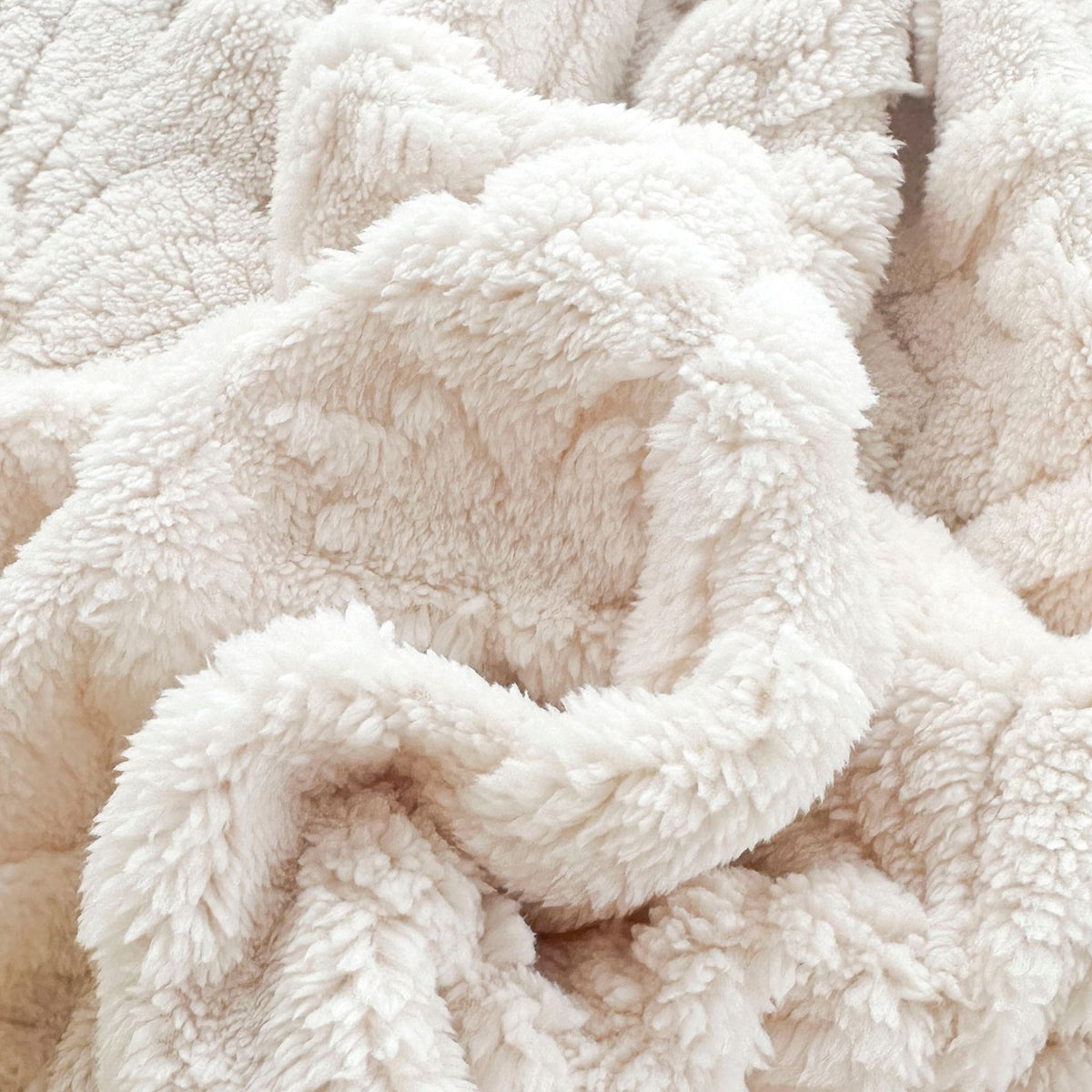 Close-up of the curly pile on the ivory fleece blanket