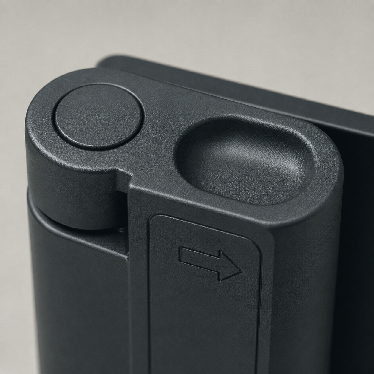 Close-up of the arm's top end showing the pivot cap and the oval thumb pocket