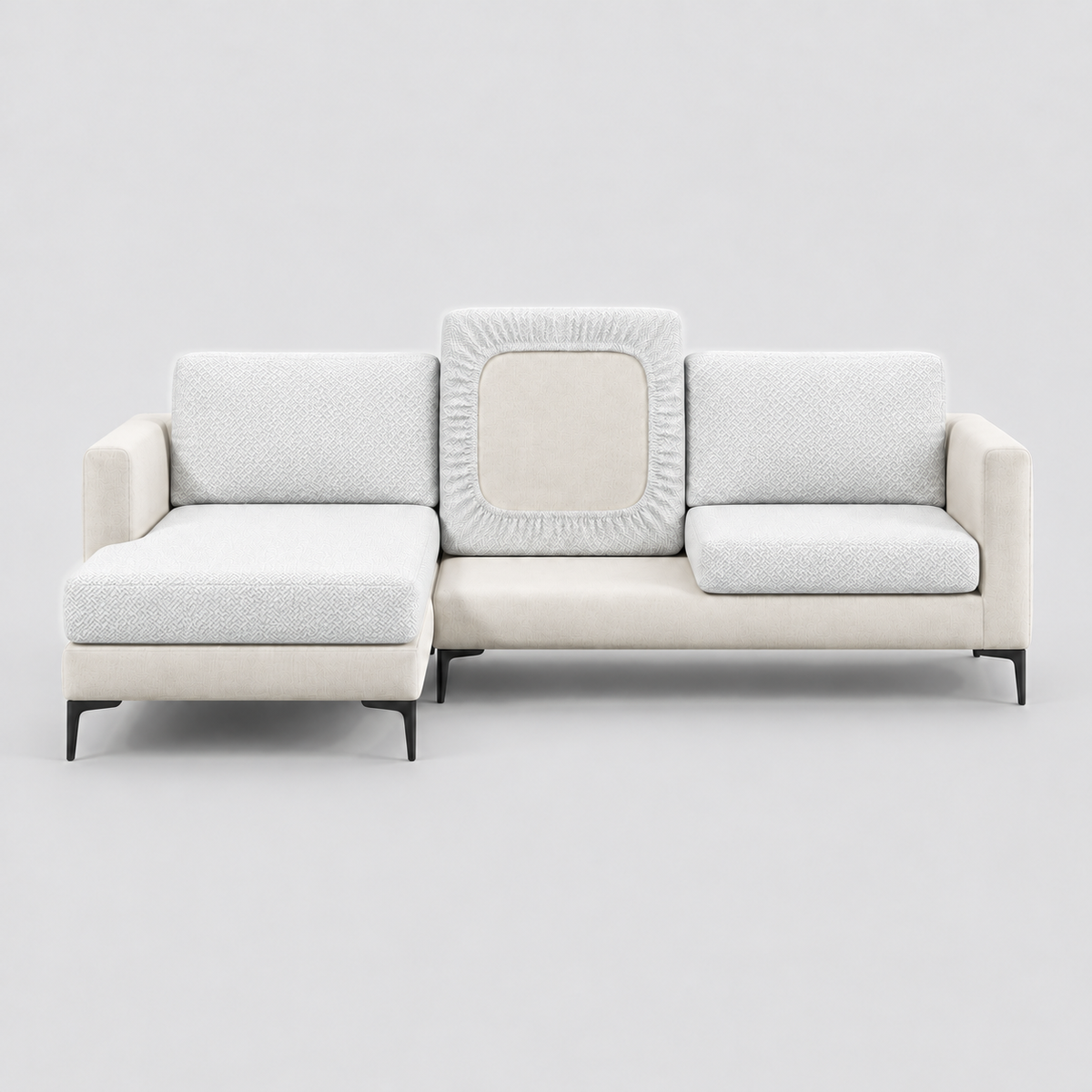 Cream L-shaped sofa face-on with white stretch cushion covers, one back cushion turned to show the elastic underside