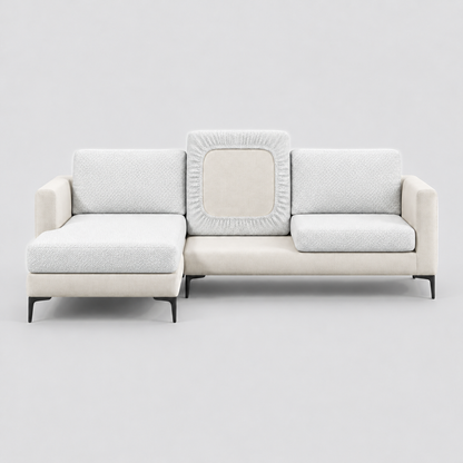 Cream L-shaped sofa face-on with white stretch cushion covers, one back cushion turned to show the elastic underside
