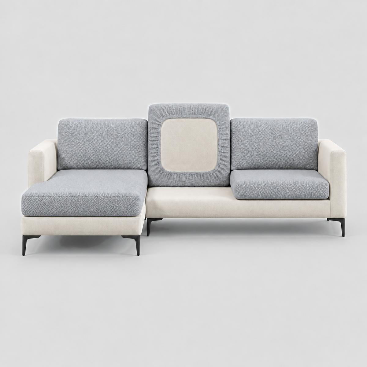 Cream L-shaped sofa face-on with grey stretch cushion covers, one back cushion turned to show the elastic underside