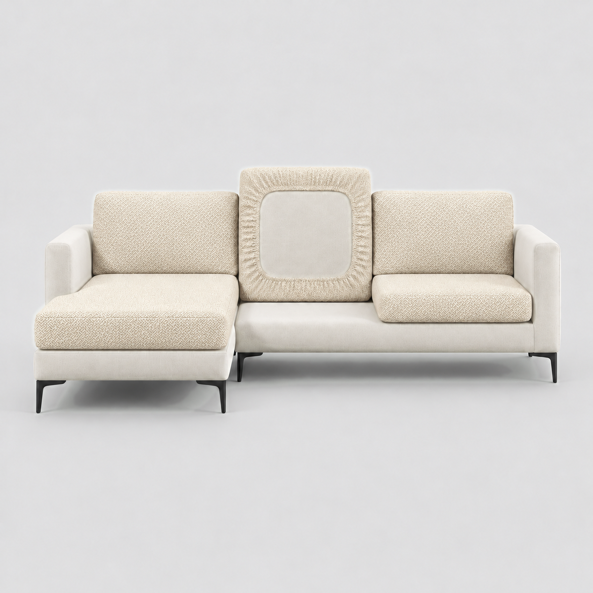 Cream L-shaped sofa face-on with beige stretch cushion covers, one back cushion turned to show the elastic underside