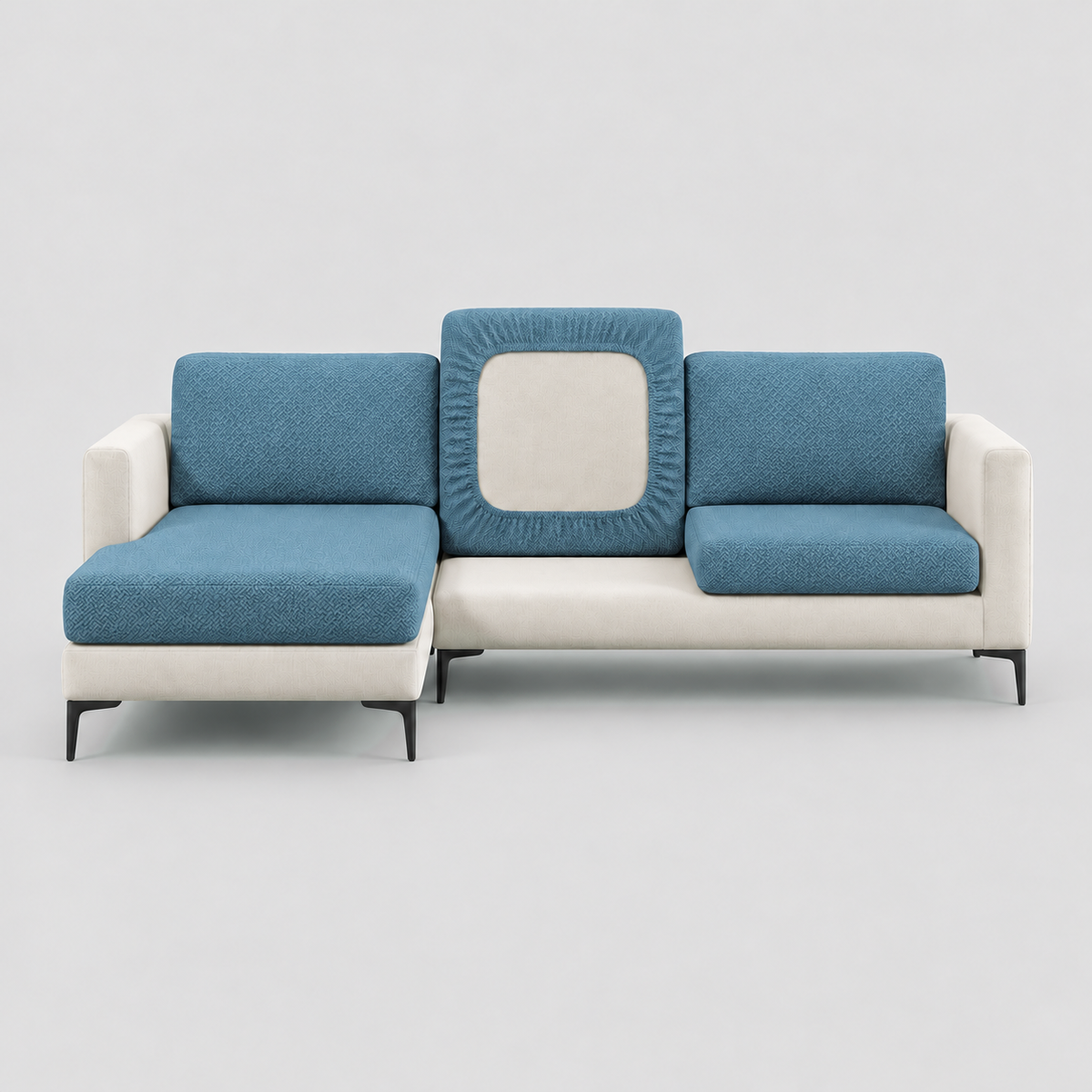 Cream L-shaped sofa face-on with blue stretch cushion covers, one back cushion turned to show the elastic underside