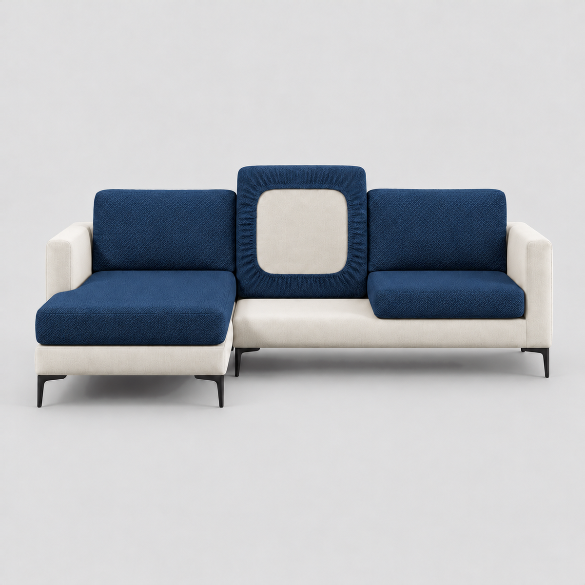 Cream L-shaped sofa face-on with navy stretch cushion covers, one back cushion turned to show the elastic underside