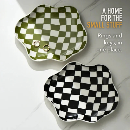 Green and black checkered ceramic trays on white marble with the words A home for the small stuff, rings and keys in one place