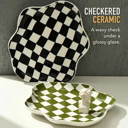 Black checkered ceramic tray propped against a grey wall with a green one in front, with the words Checkered ceramic, a wavy check under a glossy glaze