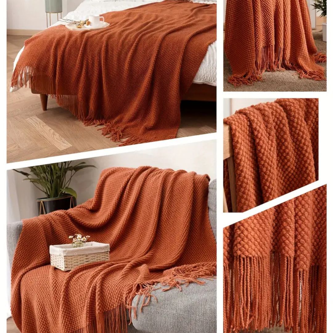 Rust tassel knit throw spread across a bed and draped on a sofa, with close-ups of the knit and fringe