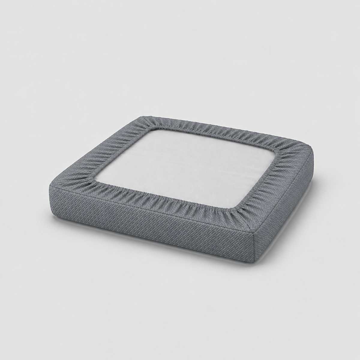 Underside of a covered seat cushion showing the charcoal cover gathered by elastic into a border on all four sides