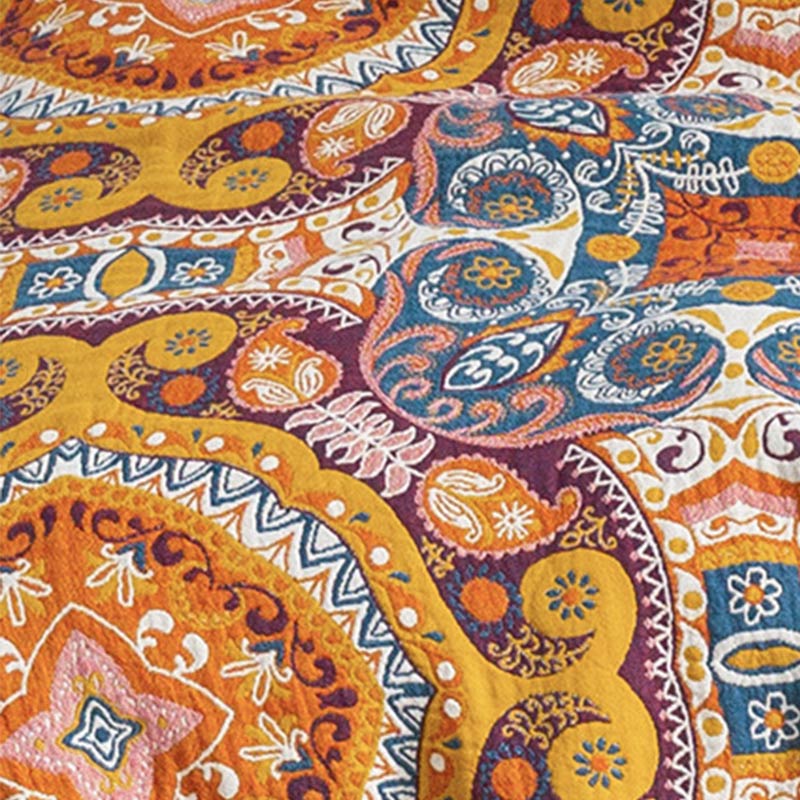 Close-up of the woven paisley and medallion pattern in orange, purple, teal and cream