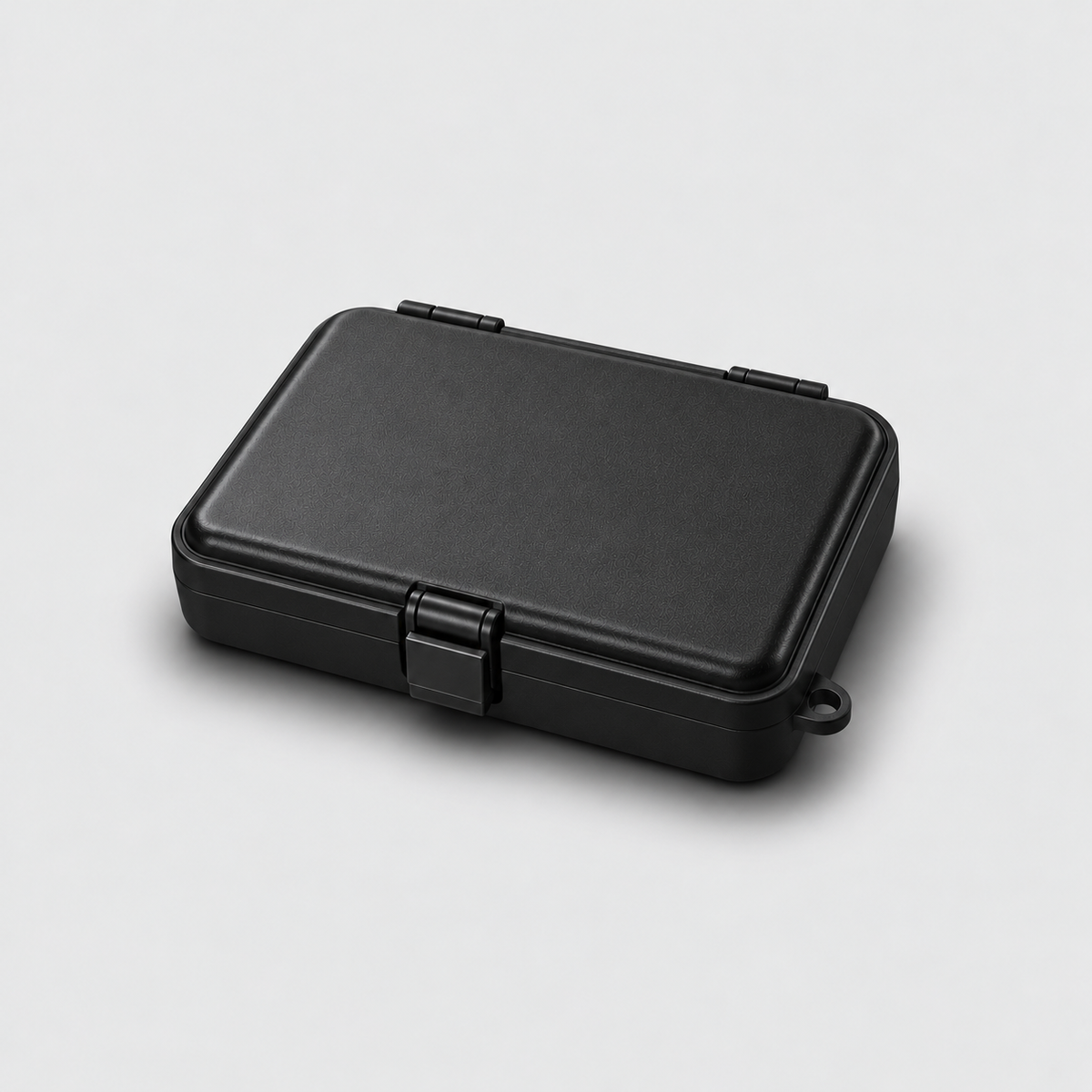 Closed black hard case from the front, showing the centred latch, on a light grey background