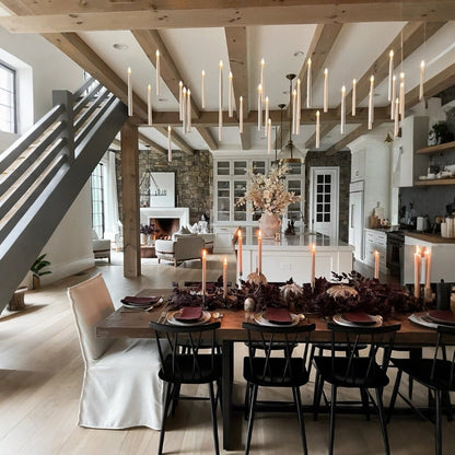 Floating LED candles hanging in rows from a beamed ceiling over an autumn dining table