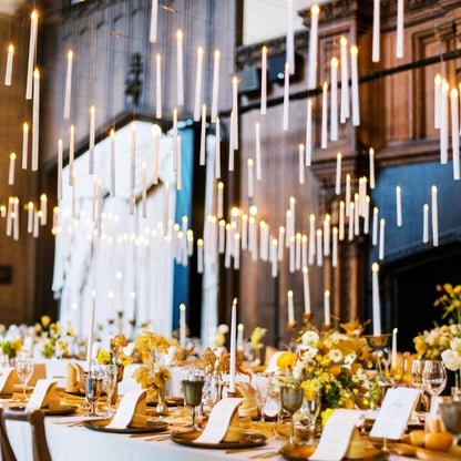 Dozens of floating LED candles above a banquet table in a panelled hall