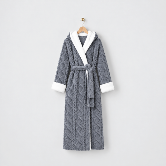 Long gray hooded plush bathrobe with a raised cable and diamond pattern, white cuffs and a tied belt, on a wooden hanger against a light gray wall