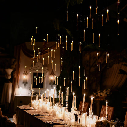 Floating LED candles above a long candlelit table in a dark ballroom