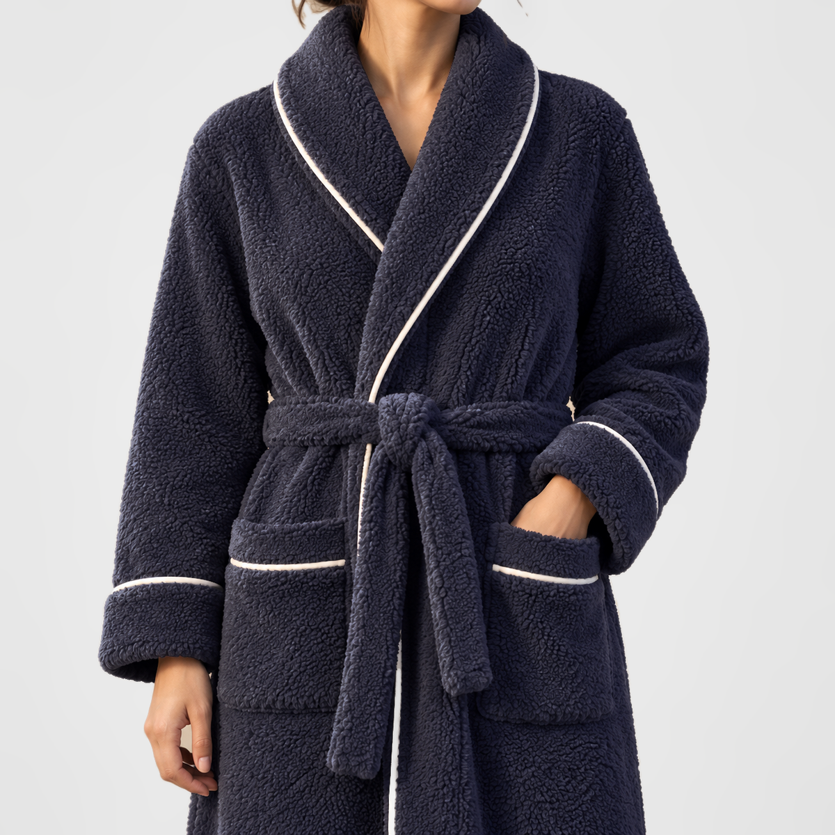 Close view of the navy fleece bathrobe's shawl collar, belt knot and piped patch pocket