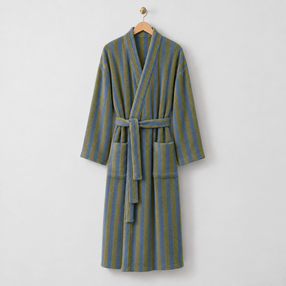 Long olive and blue striped fleece bathrobe with a kimono collar, tie belt and patch pockets, hanging on a wooden hanger on a light gray wall
