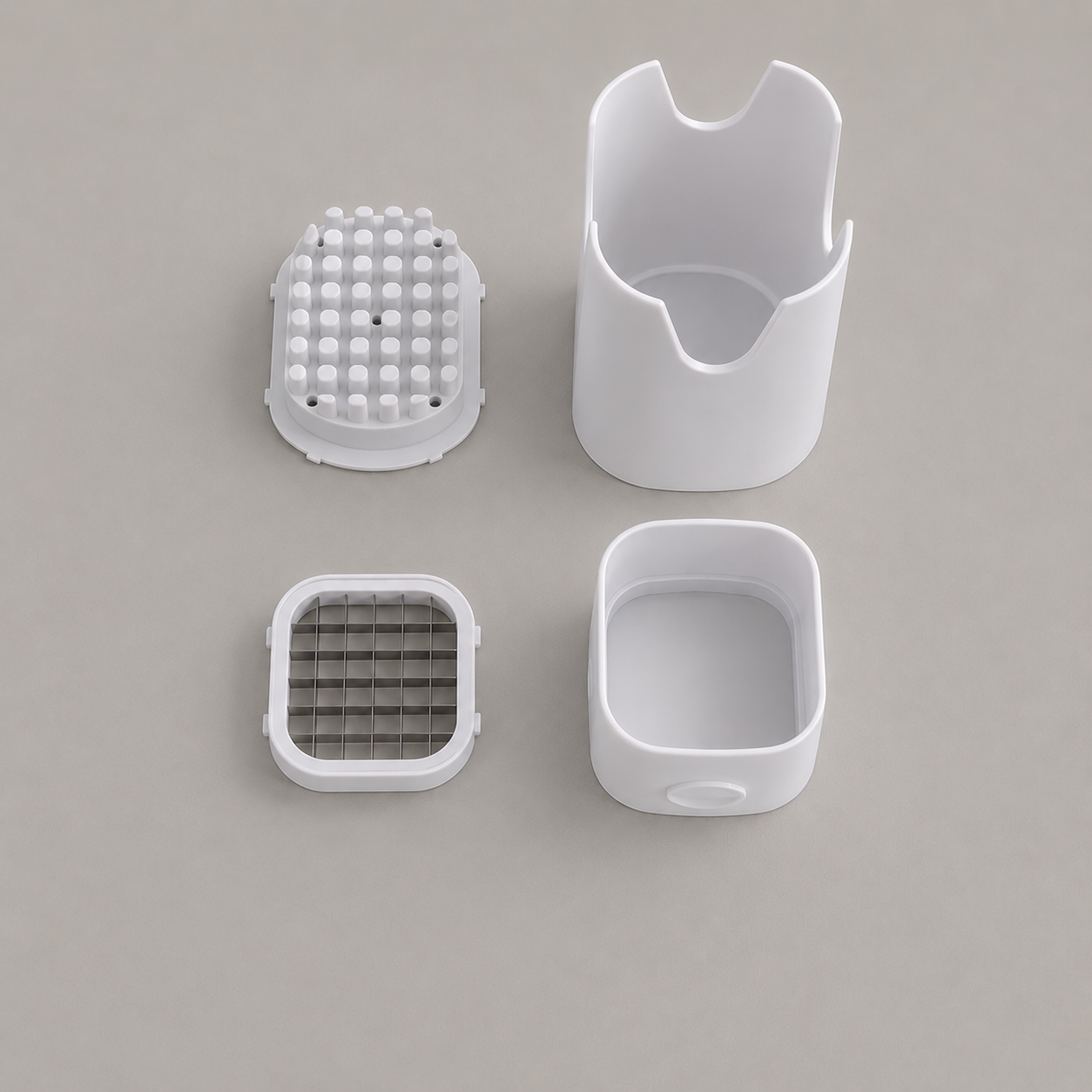 The fry cutter taken apart into its four pieces: peg plate, press shell, blade grid and catch base