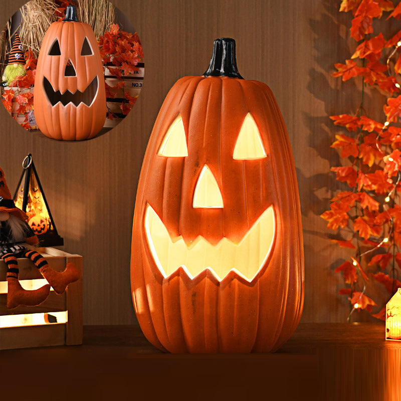 Tall Classic carved pumpkin lamp, tall and narrow, lit with triangle eyes and a wide toothy grin beside autumn leaves