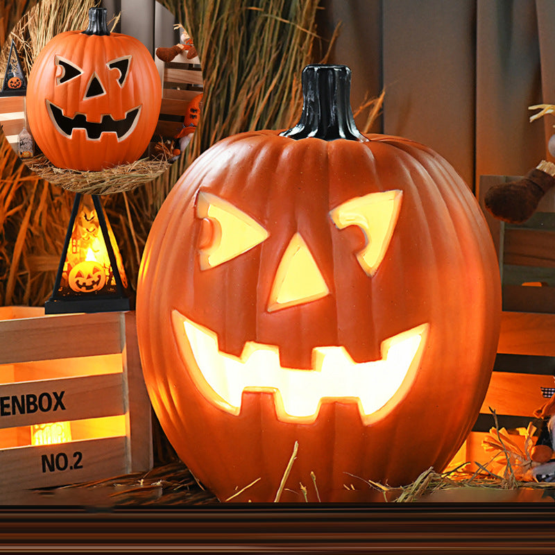 Classic Face carved pumpkin lamp lit on straw, triangle eyes and nose and a square-toothed grin