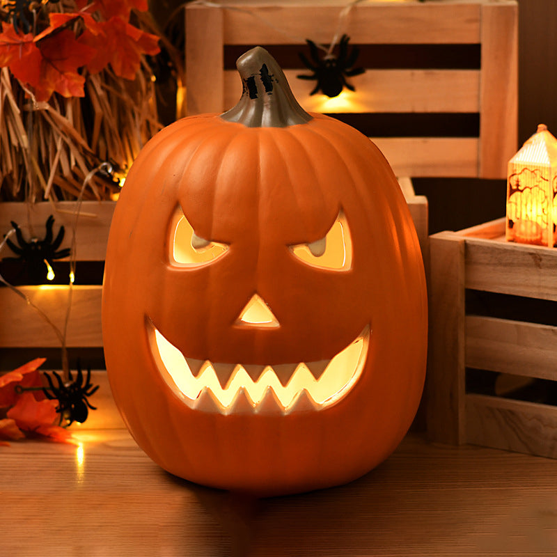 Sly Grin carved pumpkin lamp, a tall oval pumpkin lit with slanted eyes and a zigzag grin among maple leaves