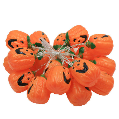 A jack-o'-lantern string light bundled up on white, the orange lanterns tied together with their clear wire