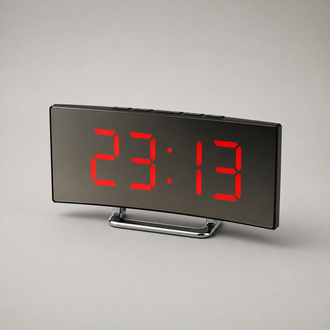 Curved LED digital alarm clock with red display, studio shot