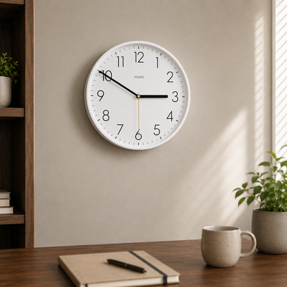 White wall clock hanging above a walnut desk in a daylit home office