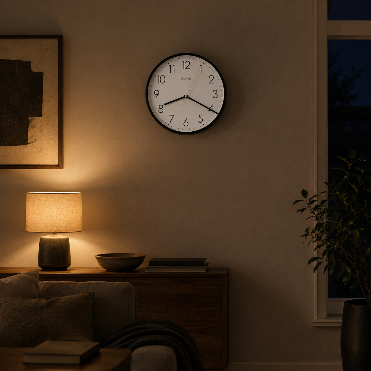Black wall clock on a living room wall in warm evening lamplight