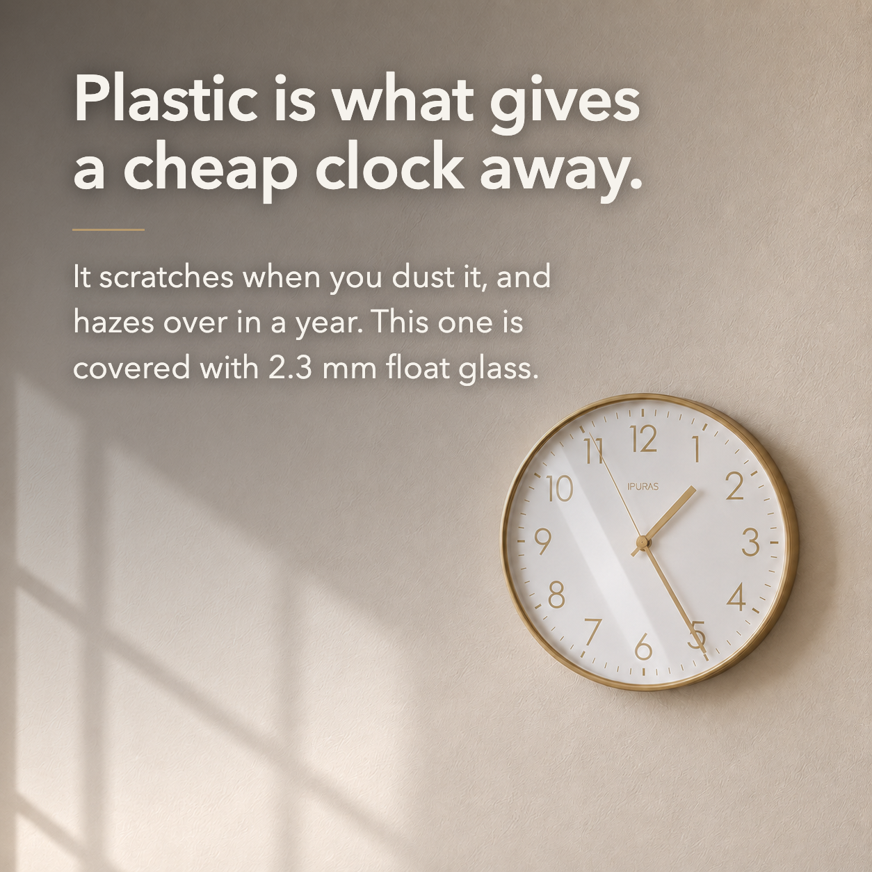 Gold wall clock on a sunlit wall with a straight window reflection lying flat across the glass