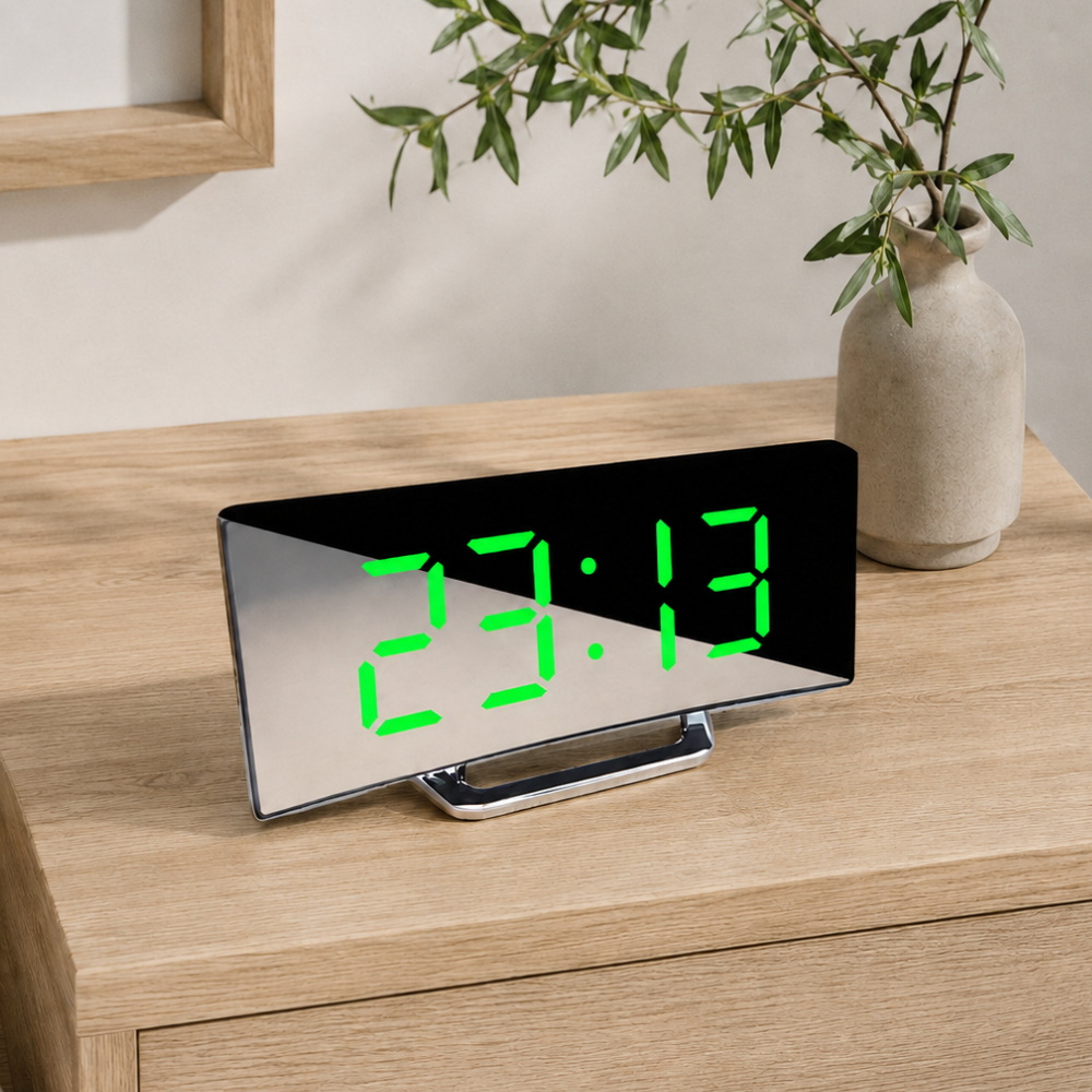 Alarm clock with green display on a wooden nightstand