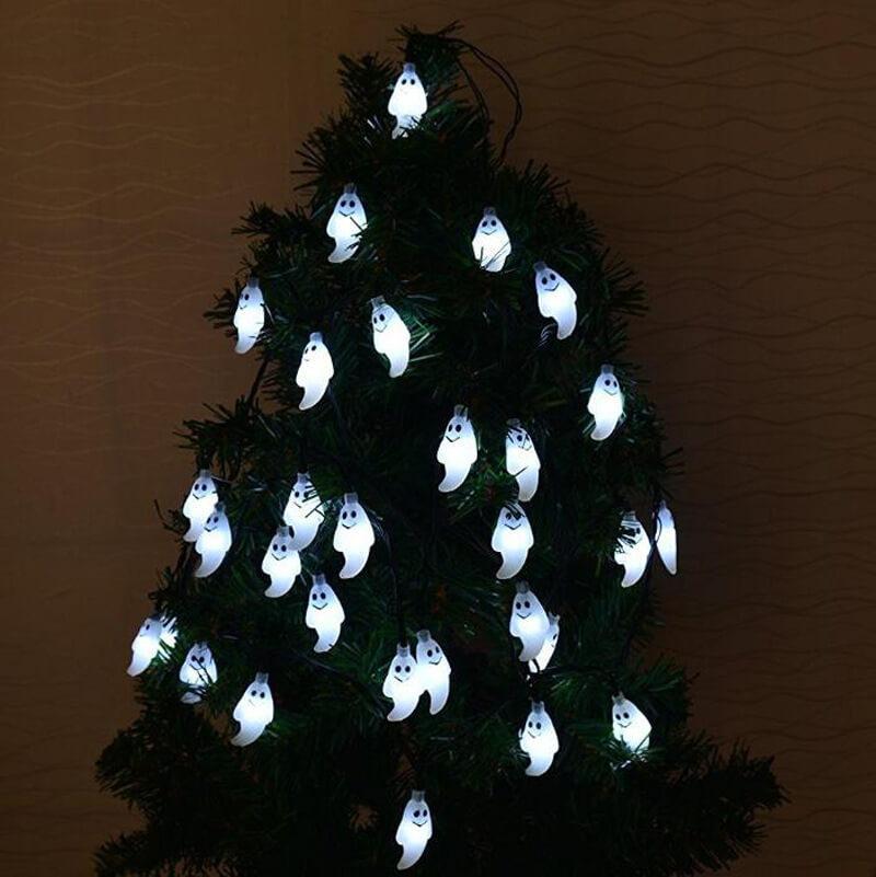 Cool white ghost string lights wound around a green artificial pine tree indoors