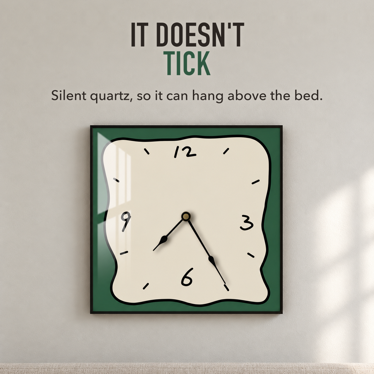 Text image: It doesn't tick. A square wall clock with a beige face and green border above a bed, silent quartz movement