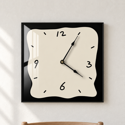Square wall clock with a beige face and a black border, hanging centred on a plain dining room wall