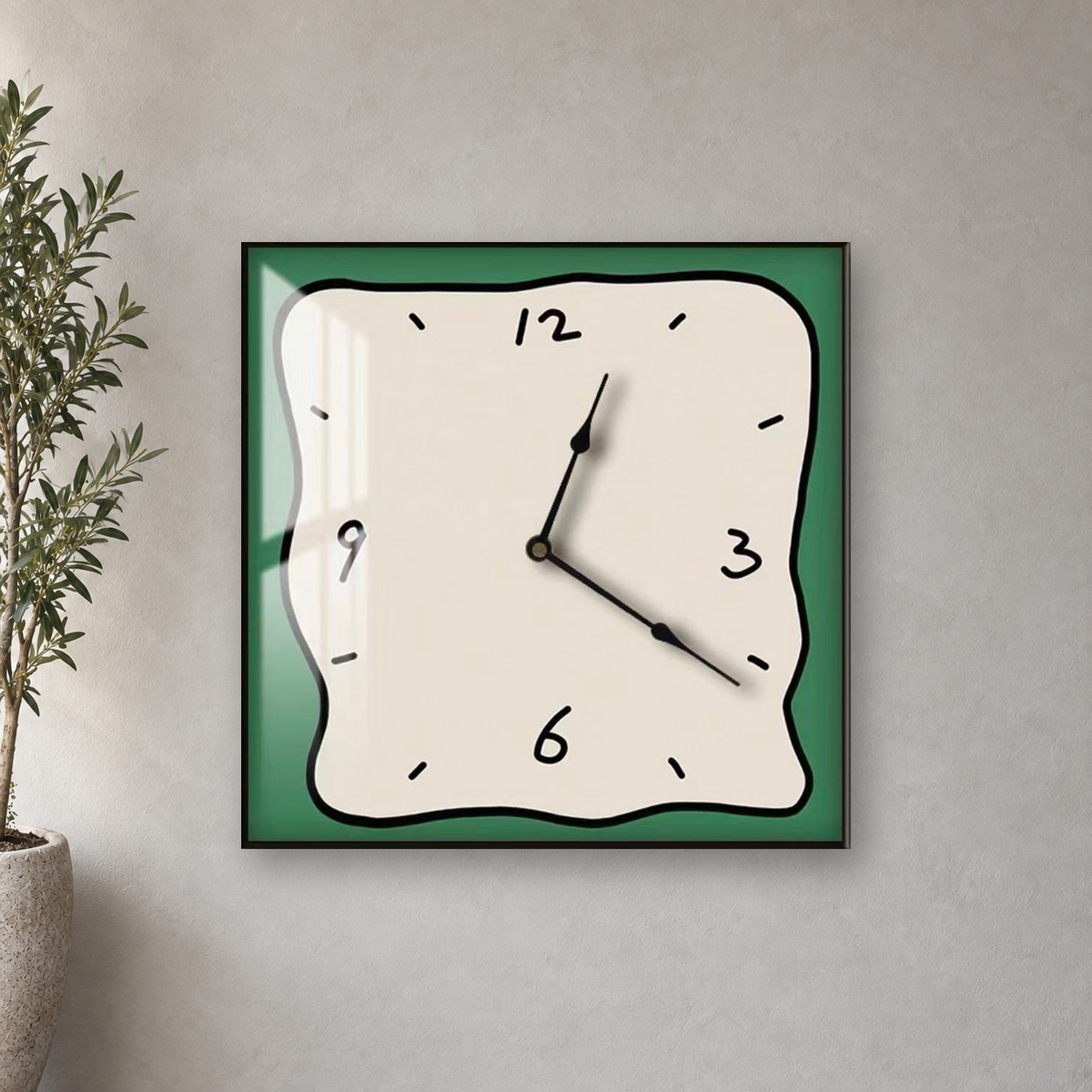 Square wall clock with a wavy doodle-style outline, a beige face and a green border, hanging centred on a limewash wall beside an olive tree