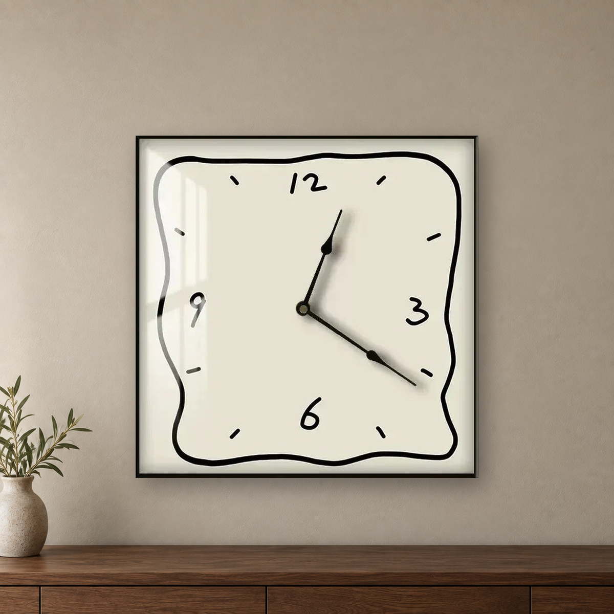 Square wall clock with a wavy doodle-style outline, a beige face and a beige border, hanging centred on a taupe wall above a walnut sideboard